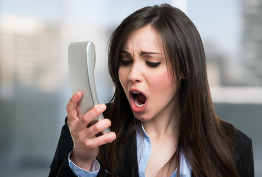 Angry businesswoman yelling on the phone