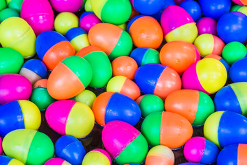 Colorful plastic eggs toys floating on the water background