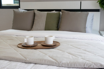 Decorative wooden tray with tea set on bed