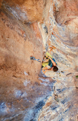 Rock climber climbing up a cliff