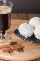 Coffee in glass cup and cinnamon with zephyr