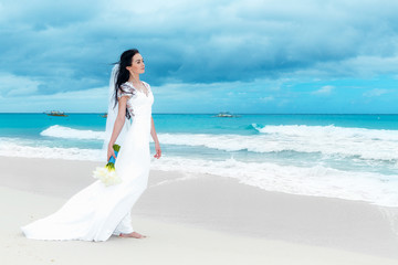 Fototapeta na wymiar beautiful fiancee in white wedding dress with big long white tra
