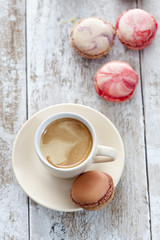 Viele bunte Macaron mit Kaffeetasse, heller Holzuntergrund