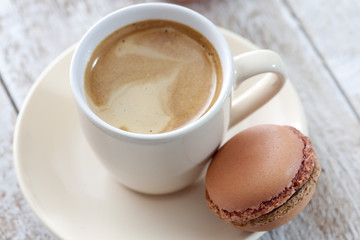 Viele bunte Macaron mit Kaffeetasse, heller Holzuntergrund