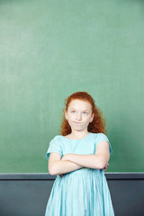 Girl in front of chalkboard in school