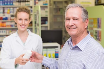 Pharmacist and costumer smiling a camera