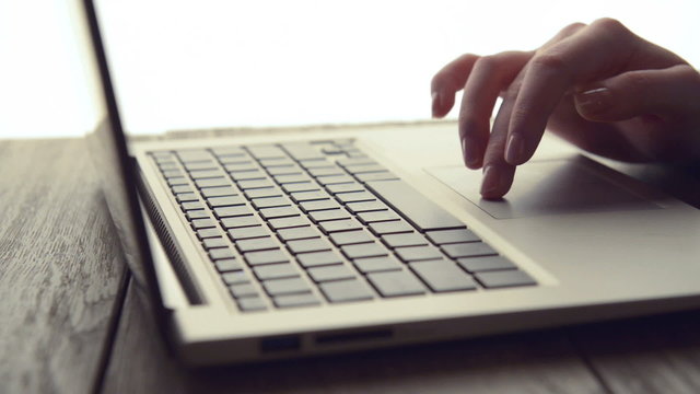 Woman Scrolls a Website Using Her Laptop