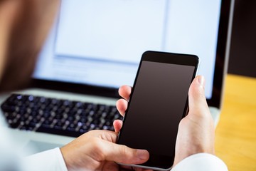 Man using laptop and smartphone