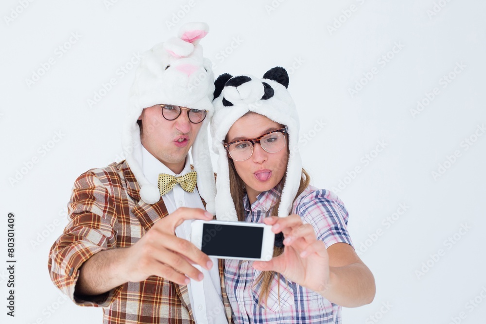 Poster geeky hipster couple taking selfie with smart phone