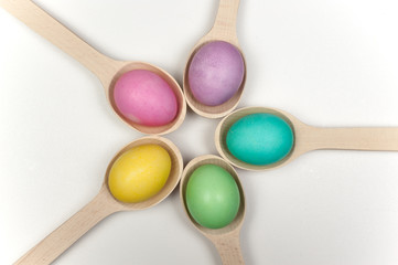 circle of colorfull easter eggs in wooden spoons isolated
