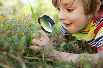 Happy little boy looking through magnifying glass © WavebreakMediaMicro