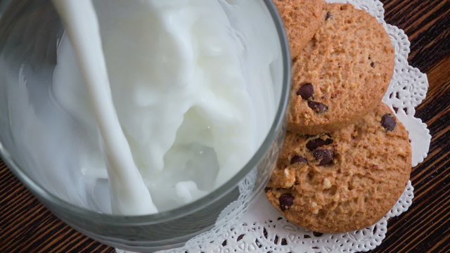 Pouring glass of milk and cookies