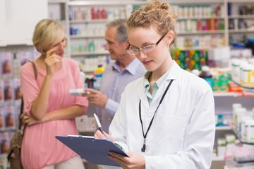 Pharmacist writing on clipboard