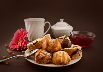 Cake roll and eclair with coffee on dark, selective focus