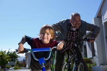 Happy father on a bike with his son