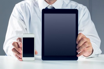 Businessman showing smartphone and tablet