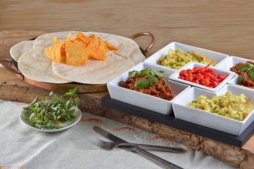 Mexican food - chilli, guacamole, tortillas and nachos