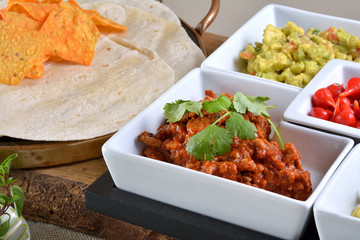 Mexican food - chilli, guacamole, tortillas and nachos