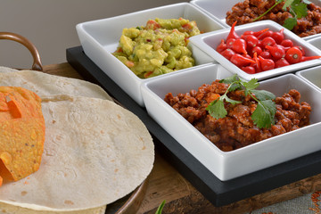 Mexican food - chilli, guacamole, tortillas and nachos