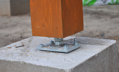 Wooden pillar installation on the construction site with screw