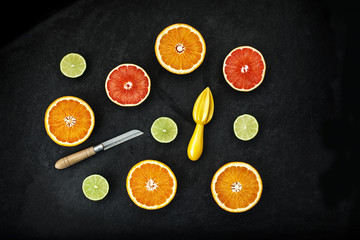 orange and lemon cut on black stone