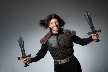 Angry knight with sword against dark background