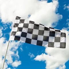 Fotobehang Formule 1 Checkered flag waving in the wind with clouds on background - ou  © niyazz