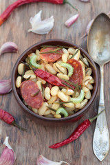Beans and chorizo cooked with vegetables and rosemary leaves.
