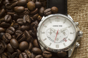 Silver watch with black leather belt and coffee beans