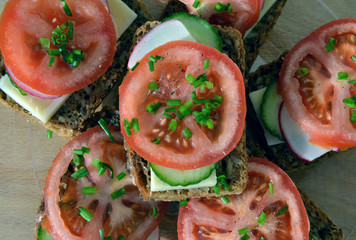 Wholemeal rye bread sandwich with tomato, cucumber, radish and c