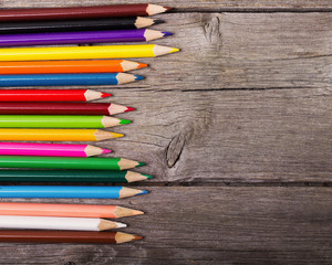 multicolored pencils on the wooden background