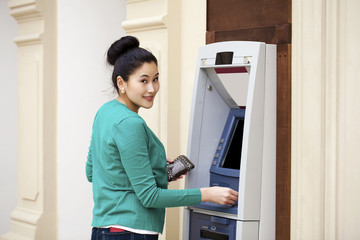 Fototapeta na wymiar Asian lady using an automated teller machine