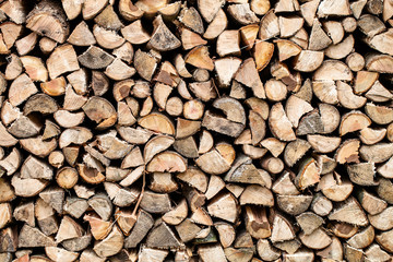 Dry chopped firewood stacked up in a pile ready for winter