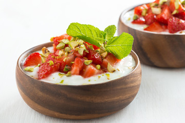 dessert of yogurt with fresh strawberries, pistachios and mint