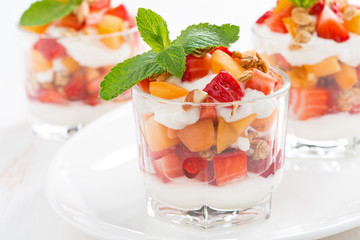 dessert with strawberries, apricots, whipped cream and granola