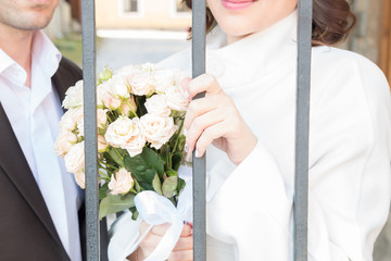 bride and groom behind bars