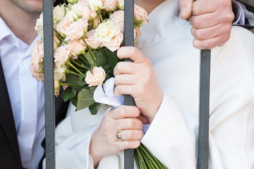 bride and groom behind bars
