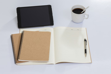 Blank notebook and office accessories on white table