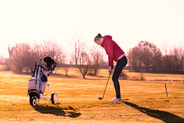 Weiblicher Golfer chippt den Golfball in Richtung Fahne