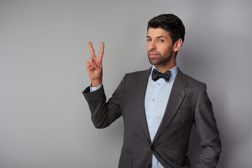 Man showing victory sign and looking at camera