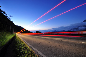 Light car trails in a road, twilight blue sky