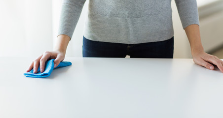 close up of woman cleaning table with cloth