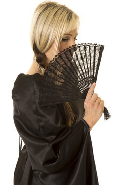 woman in black cloak side behind fan