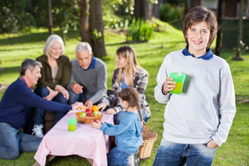 Boy Holding Glass Of Juice At Campsite