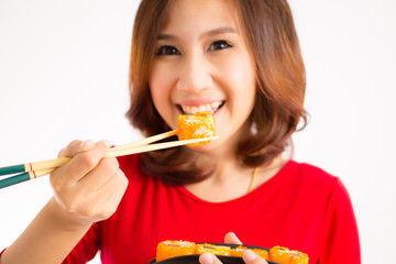 Close-up. young lady eating sushi roll