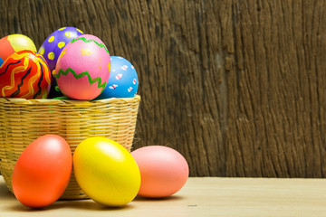 Fototapeta na wymiar Easter eggs in basket and wood background
