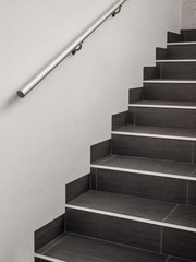 Moderne gekachelte Treppe mit Handlauf aus Edelstahl