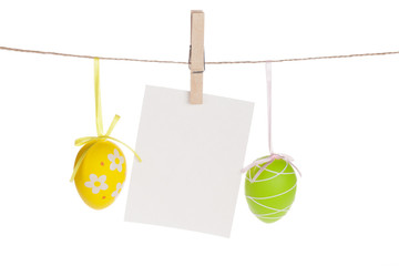 Colorful easter eggs and blank photo frame hanging on rope