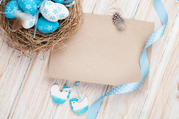 Fototapeta na wymiar Easter greeting card with blue and white eggs in nest and decor