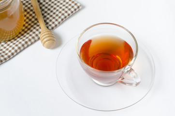 a cup of tea with honey on white background